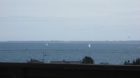 Aussicht aus der Lounge/Sonnenterrasse Hier sehen Sie einen kleinen Ausschnitt der Sicht aus der Lounge. In Natura ist die Sicht 4 - 5 Mal breiter. Die Lounge hat den 100% Kuschelfaktor. Sie finden dort auch eine kleine Pantry, damit Sie Ihren Kaffee oder Tee kochen können. Ein Flachbild-TV und eine Musikanlage runden alles ab. Auch gibt es hier oben eine Toilette. Im Anschluss an die Lounge gelangen Sie direkt auf die grosse Sonnen-Terrasse mit traumhaften Meerblick, der Sie umhauen wird. - Bild 1: Top-Ferienhaus Ostsee Meersicht Hunde Nahe Grömitz